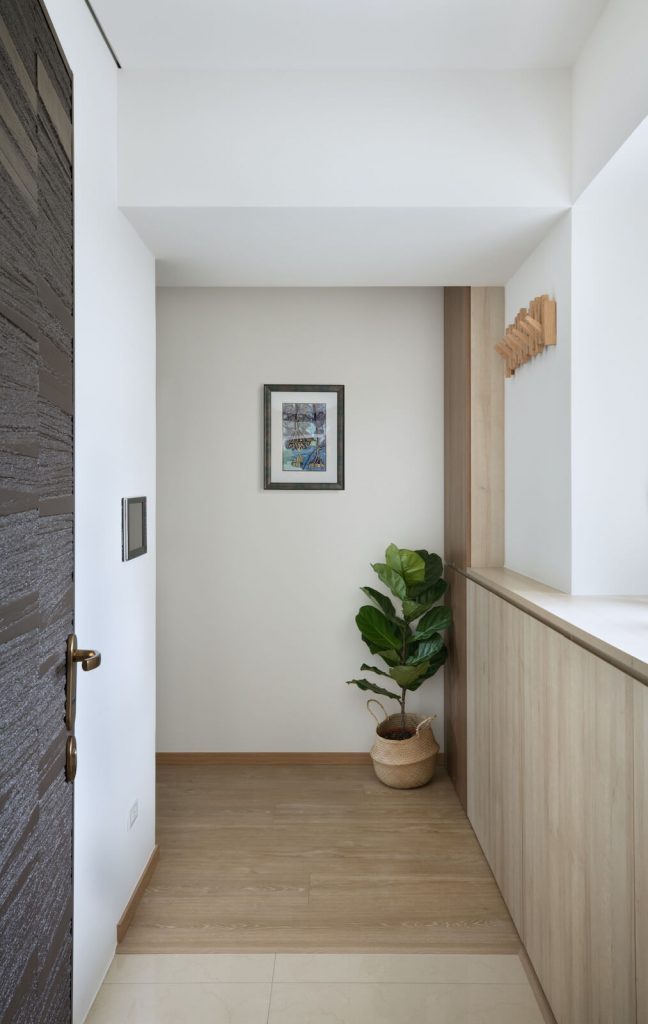 木地板與地磚高低差正好成為入口落塵區，阻絕砂塵入室內。在柱面設置外出衣架，造型美觀又實用