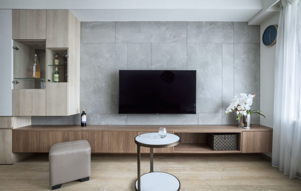 客廳電視牆以灰色磁磚拼貼，搭配深、淺色系系統櫃，成為最吸睛牆面。