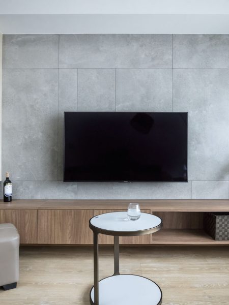 客廳電視牆以灰色磁磚拼貼，搭配深、淺色系系統櫃，成為最吸睛牆面。